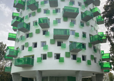 edificio blanco con balcones verdes