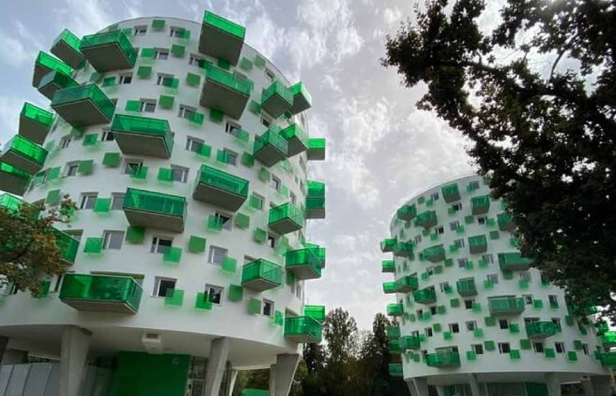 Edificio blanco con balcones verdes