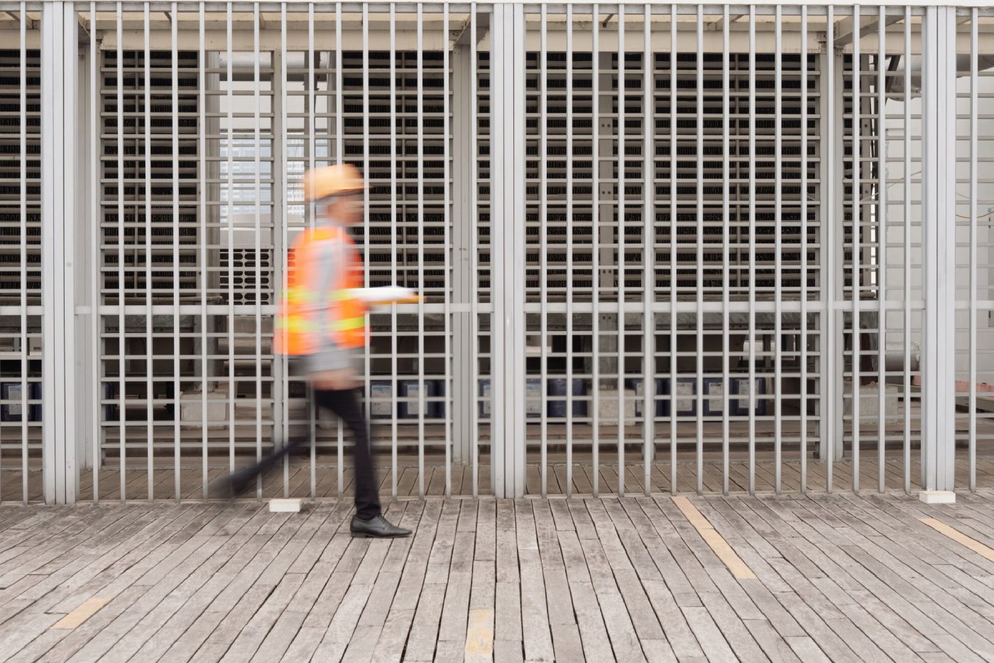 trabajador pasando por enfrente de una valla de seguridad